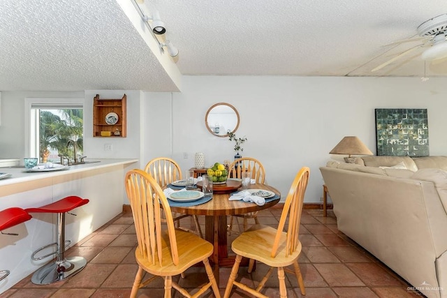 dining room with tile patterned floors, a textured ceiling, and a ceiling fan