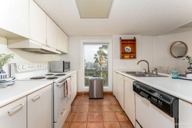 kitchen featuring visible vents, light countertops, white cabinets, white appliances, and a sink