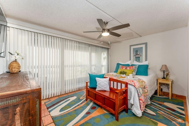 bedroom with access to exterior, a textured ceiling, and a ceiling fan