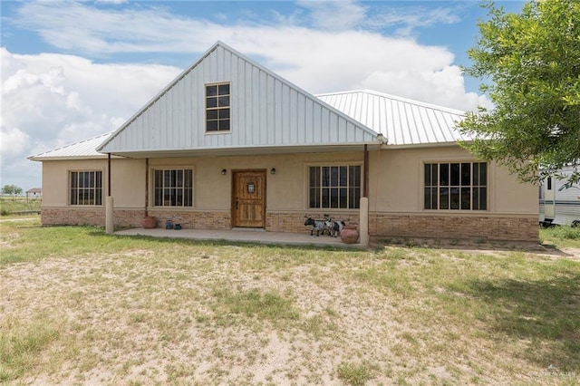 25662 N Fm 681, Edinburg, TX 78541 - view of front facade with stucco siding, stone siding, a front yard, and a metal roof
