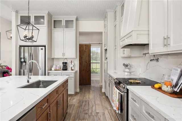 kitchen featuring white cabinetry, sink, pendant lighting, appliances with stainless steel finishes, and light wood-type flooring