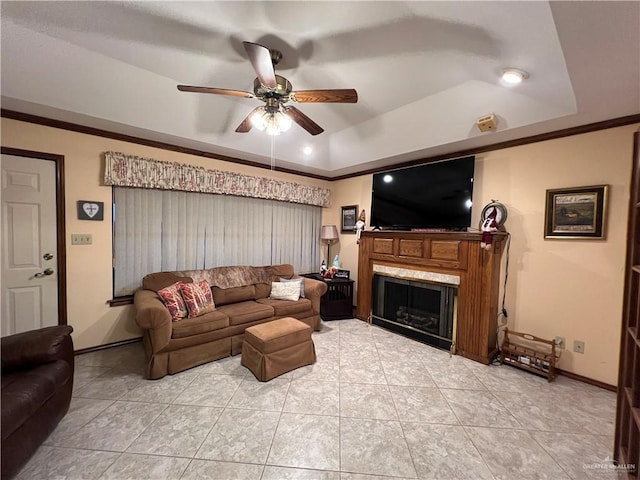 7226 Ford St, Mission, TX 78572 - living room with a tray ceiling, a ceiling fan, a fireplace, ornamental molding, and light tile patterned flooring