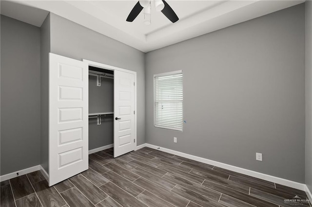 unfurnished bedroom with baseboards, a closet, and wood tiled floor