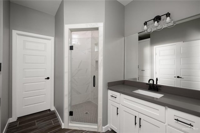 full bathroom with baseboards, a stall shower, vanity, and wood tiled floor