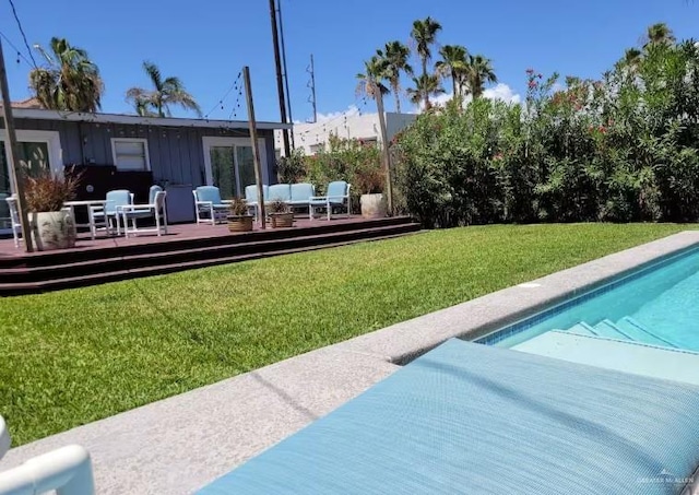 102 E Tarpon St, South Padre Island, TX 78597 - rear view of house featuring a wooden deck, an outdoor hangout area, a yard, an outdoor pool, and board and batten siding