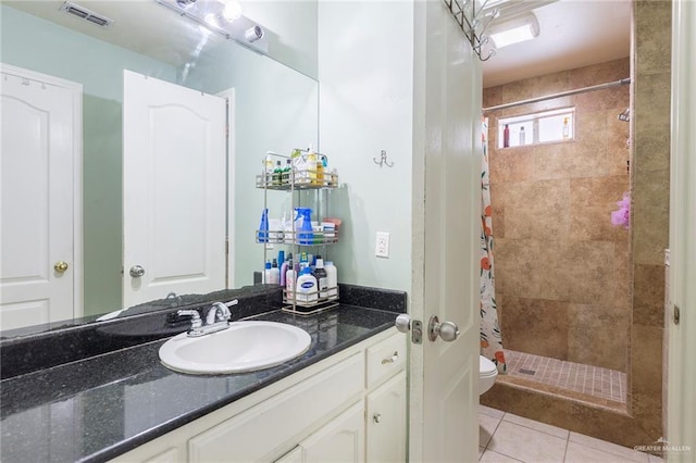 bathroom featuring toilet, a shower with curtain, tile patterned floors, and vanity