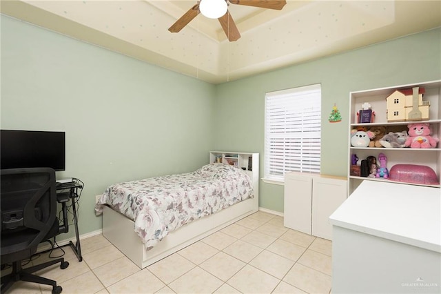 tiled bedroom featuring ceiling fan and a raised ceiling