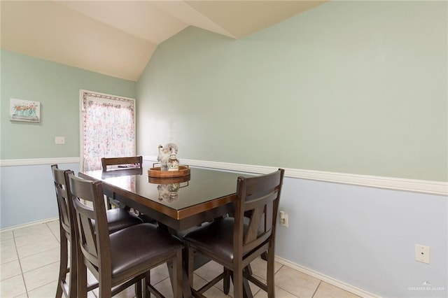 dining area featuring lofted ceiling and light tile patterned flooring