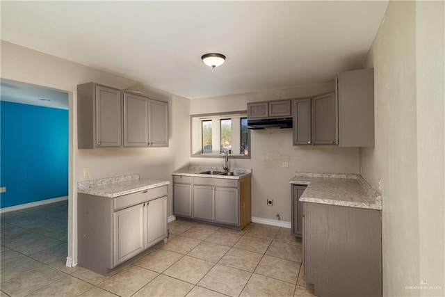 kitchen featuring sink, light tile patterned floors, and gray cabinetry