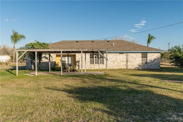 rear view of house featuring a lawn and a patio