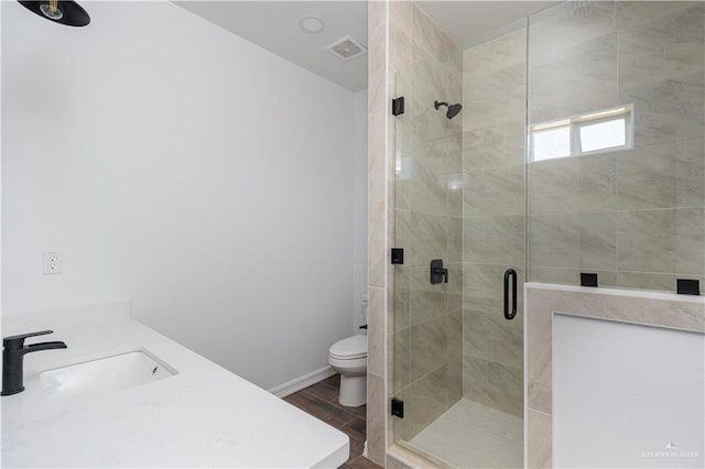 bathroom with wood-type flooring, toilet, a shower with shower door, and sink