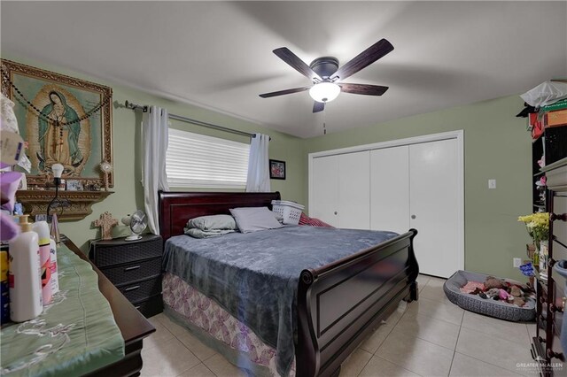 tiled bedroom with ceiling fan and a closet