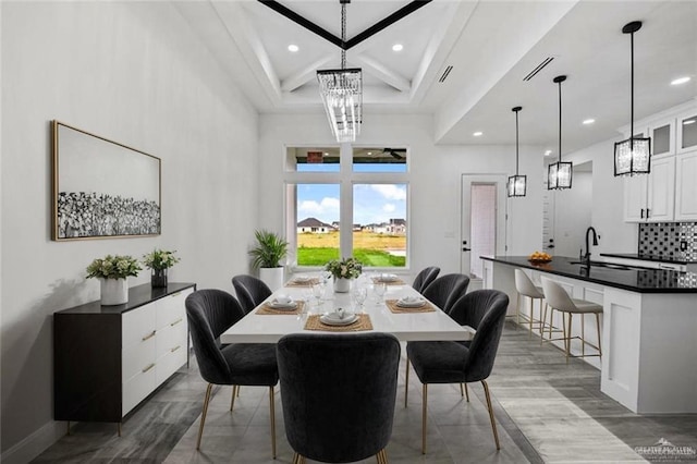 dining space with dark hardwood / wood-style floors, coffered ceiling, a chandelier, and sink