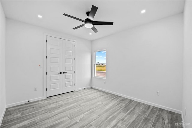 empty room with ceiling fan and light wood-type flooring