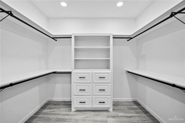 walk in closet with light hardwood / wood-style flooring