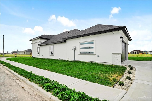 view of side of property with a garage and a lawn