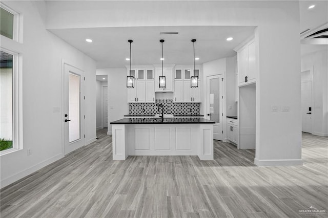 kitchen featuring sink, decorative light fixtures, light hardwood / wood-style floors, and white cabinets