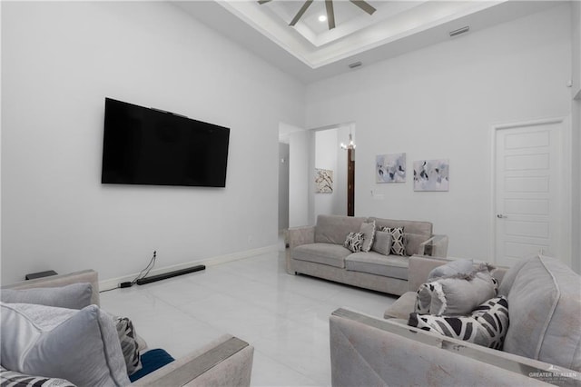 1213 N Garden Ridge Ave, San Juan, TX 78589 - living area with a ceiling fan, a towering ceiling, light marble finish floors, baseboards, and a raised ceiling