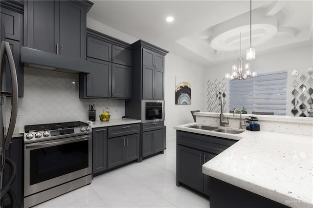 1213 N Garden Ridge Ave, San Juan, TX 78589 - kitchen with stainless steel range with gas stovetop, decorative backsplash, a chandelier, under cabinet range hood, and light stone counters