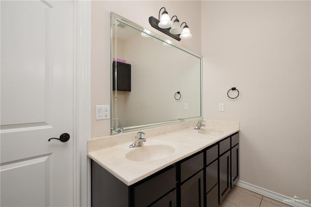 full bath featuring double vanity, tile patterned flooring, baseboards, and a sink