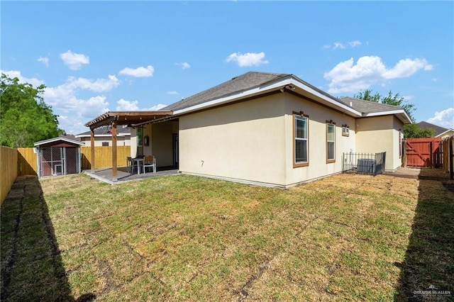 rear view of property with an outdoor structure, a patio area, stucco siding, central AC unit, and a fenced backyard