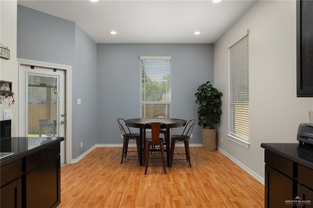 dining room with light wood finished floors, baseboards, and recessed lighting