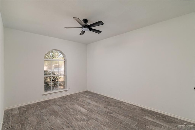 empty room featuring ceiling fan, baseboards, and dark wood finished floors