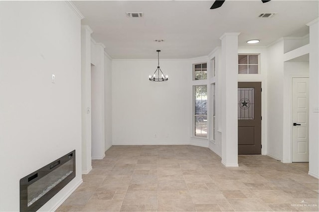 unfurnished dining area featuring crown molding, ceiling fan with notable chandelier, visible vents, and baseboards