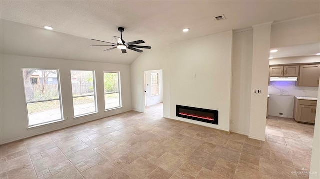 unfurnished living room with visible vents, a ceiling fan, a glass covered fireplace, vaulted ceiling, and baseboards