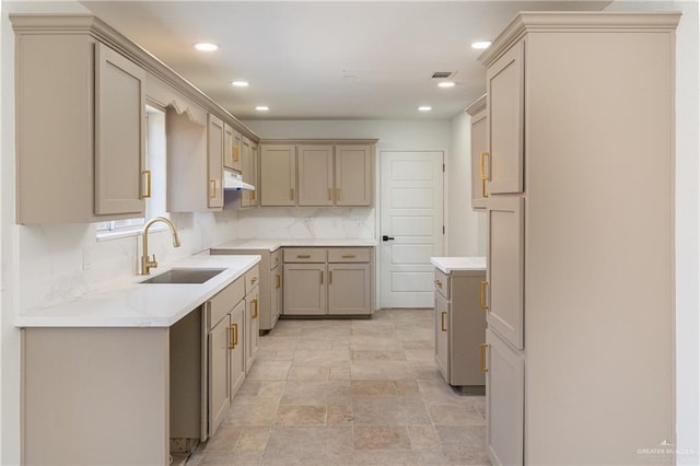 kitchen with a sink, decorative backsplash, under cabinet range hood, and recessed lighting