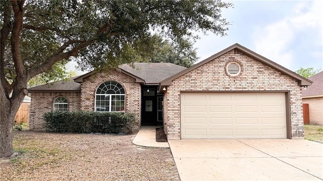 ranch-style house featuring a shingled roof, brick siding, driveway, and an attached garage