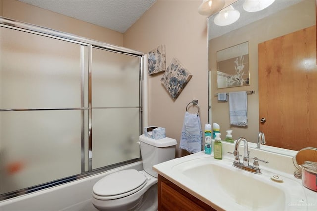 full bathroom with bath / shower combo with glass door, vanity, a textured ceiling, and toilet