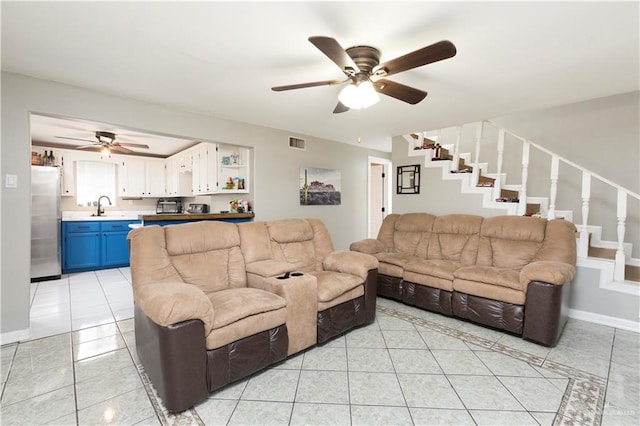 tiled living room with ceiling fan and sink