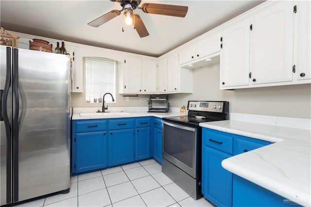 kitchen featuring sink, blue cabinets, stainless steel appliances, and light tile patterned floors