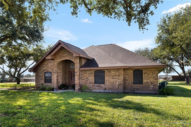 view of front of property with central air condition unit and a front lawn