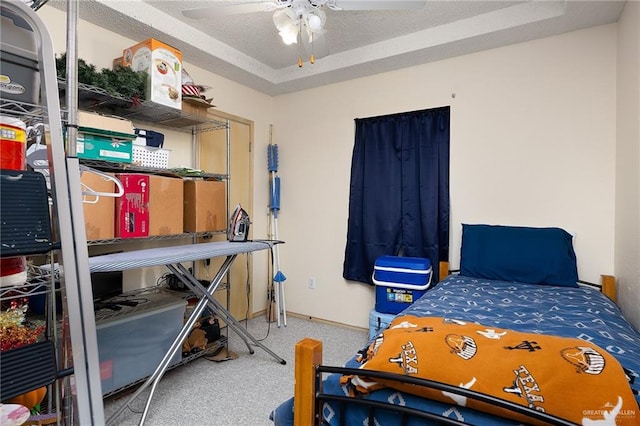 bedroom featuring carpet flooring, ceiling fan, and a textured ceiling