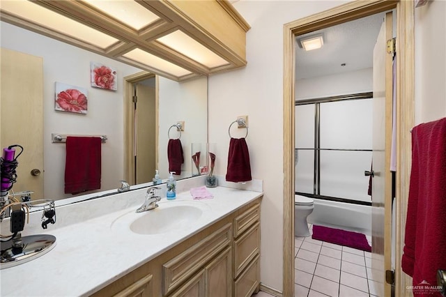 full bathroom with tile patterned floors, toilet, vanity, and combined bath / shower with glass door