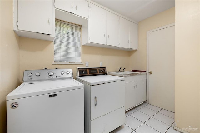 laundry room featuring cabinets, light tile patterned flooring, washing machine and dryer, and sink