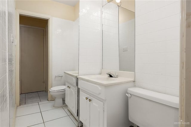 bathroom featuring tile patterned floors, vanity, toilet, and tile walls