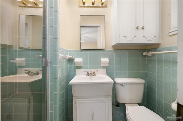 bathroom with toilet, vanity, tile walls, and walk in shower