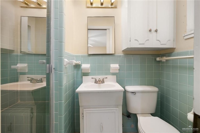 1201 W Fern Ave, Mcallen, TX 78501 - bathroom featuring tile walls, toilet, vanity, a shower stall, and a wainscoted wall