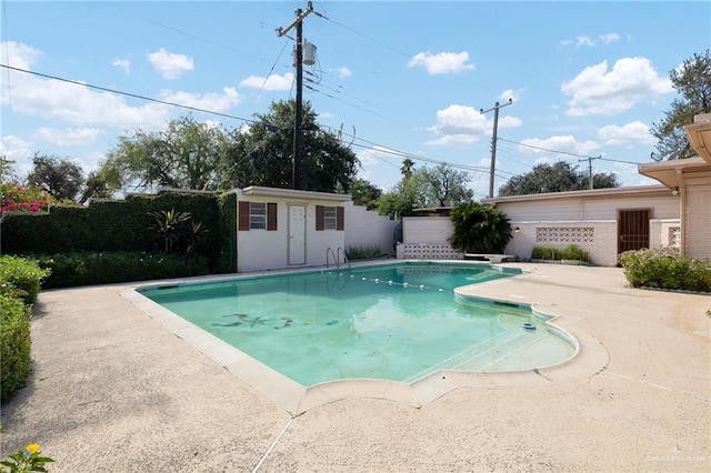 view of swimming pool with a patio and an outdoor structure