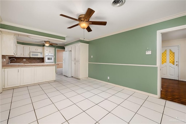 kitchen with backsplash, white cabinetry, white appliances, and ornamental molding