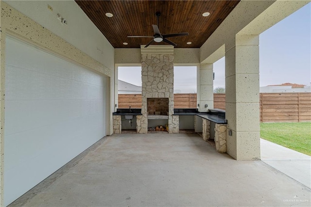 view of patio with an outdoor kitchen, fence, and a ceiling fan