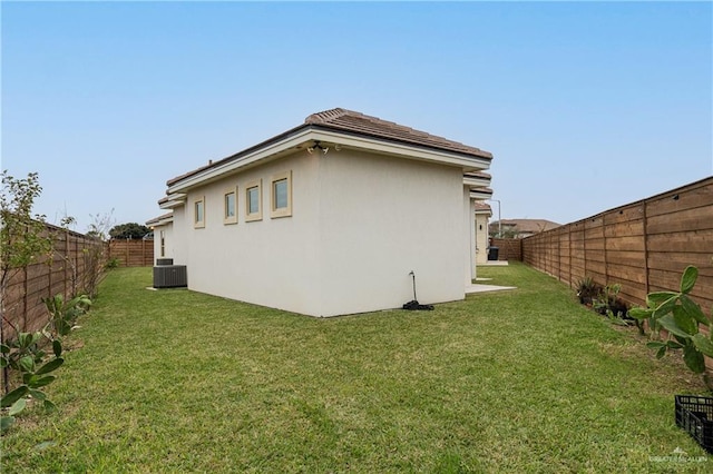 exterior space featuring a yard, cooling unit, a fenced backyard, and stucco siding