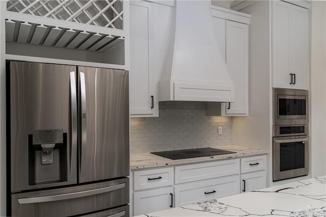 kitchen with premium range hood, appliances with stainless steel finishes, white cabinets, and light stone counters