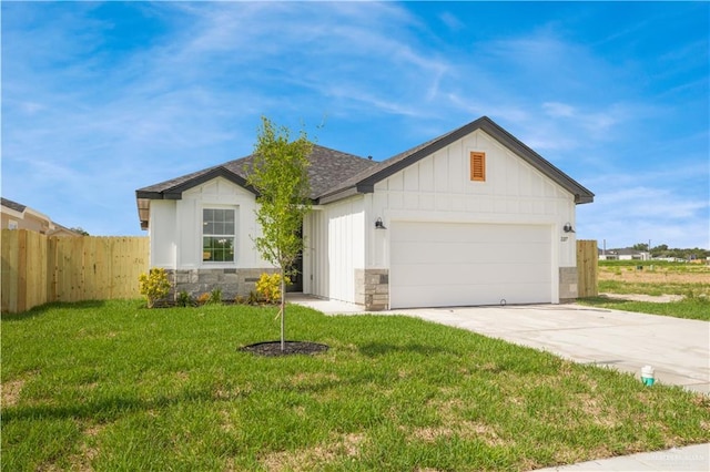 2217 Cardinal Dr, Weslaco, TX 78596 - view of front of home featuring concrete driveway, an attached garage, stone siding, board and batten siding, and roof with shingles