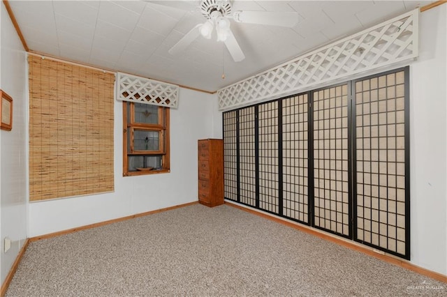 carpeted spare room featuring ceiling fan