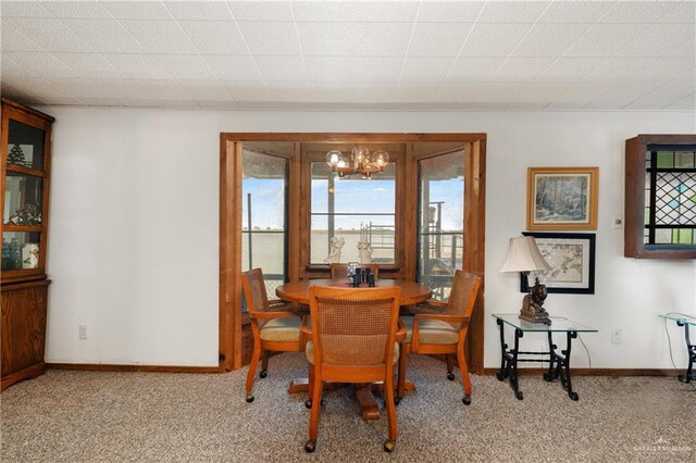 dining area with carpet and an inviting chandelier