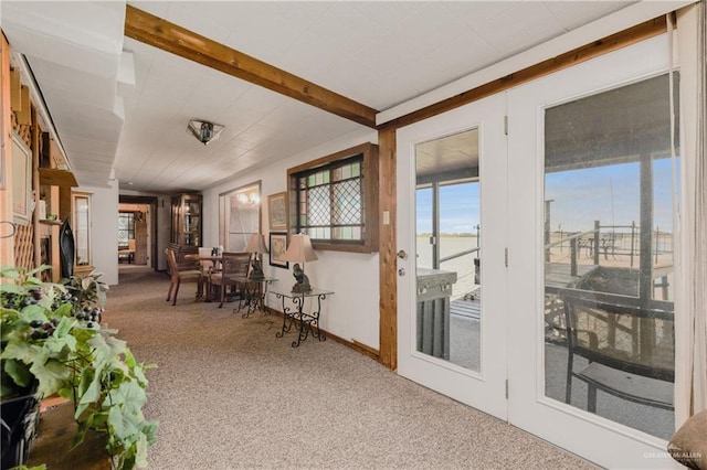 sunroom / solarium featuring beamed ceiling